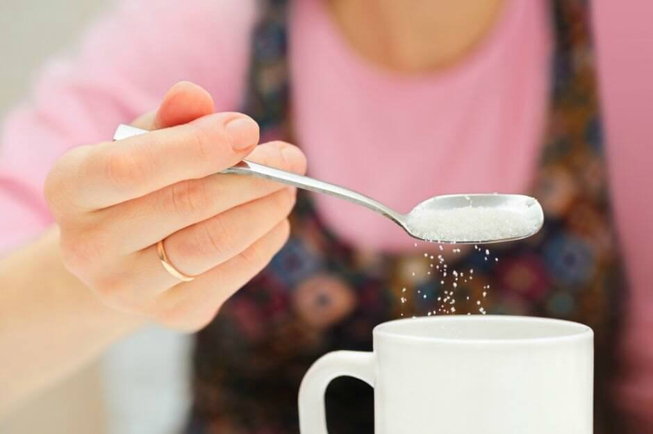 woman-putting-sugar-in-tea-coffee