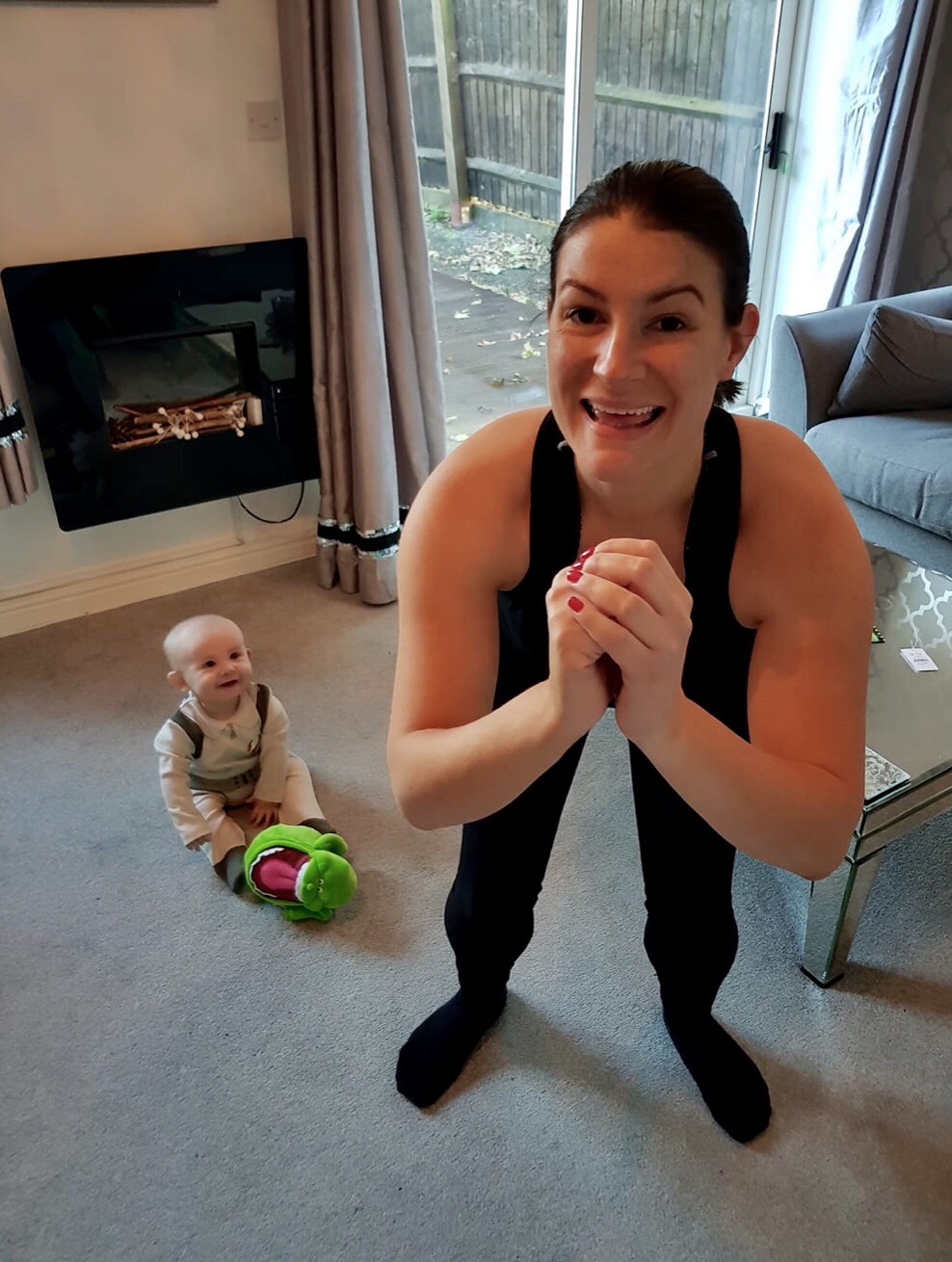 Mum doing squat next to baby