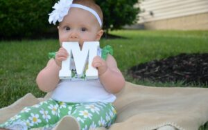 baby chewing on letter M