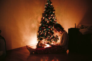 Girl feeling blue in front of a Christmas tree